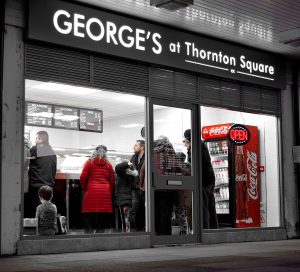 Macclesfield Takeaways illustrated by view at night time of shop front for Georges at Thornton Square