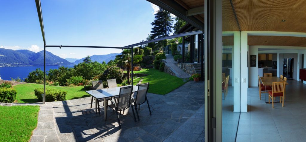Distorted view of this holiday home on Lake Maggiore showing the thin glass wall between indoors and outdoors.